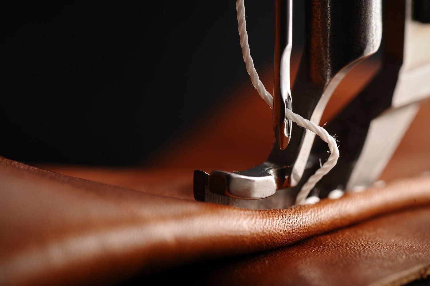 Máquina de costura industrial trabalhando uma peça de couro