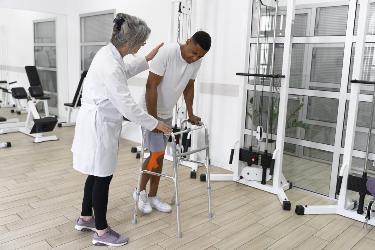 Fisioterapeuta conduzindo treino de marcha com andador